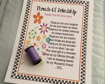 May include: A purple spool of thread with a white card that reads "Threads of Friendship" with a poem about friendship. The card has a black and white checkered border.