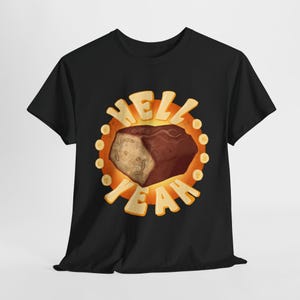 May include: Black t-shirt with a graphic of a brown and tan chocolate bar in a yellow circle with the text "Hell Yeah" around it.