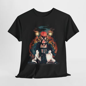 May include: Black t-shirt with a graphic of a person with a pumpkin head holding a staff and surrounded by other figures. The graphic is set against a dark background with a red and orange moon.