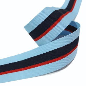 May include: Light blue ribbon with a navy blue stripe and a red stripe.