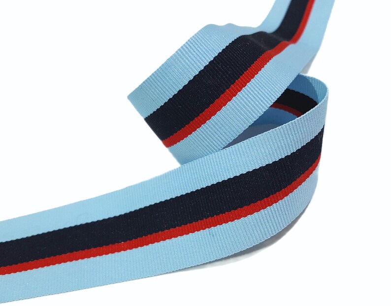 May include: Light blue ribbon with a navy blue stripe and a red stripe.