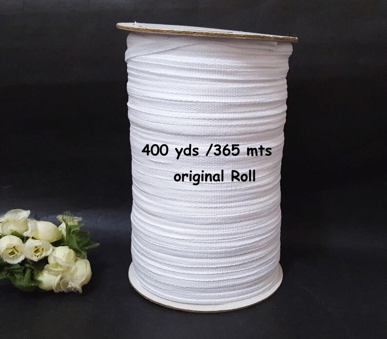 May include: A white elastic band on a cardboard roll. The roll is labeled "400 yds / 365 mts original Roll".