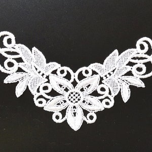 May include: White lace trim featuring a floral design. The trim has a central flower with five petals and leaves on either side.