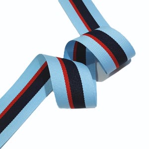 May include: Light blue ribbon with red and navy blue stripes.