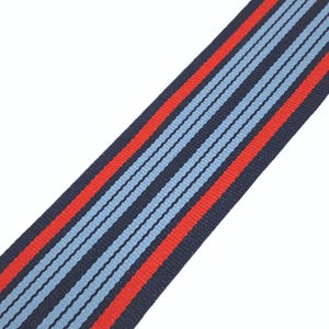 May include: A blue and red striped ribbon with a white background. The ribbon is made of a woven fabric and has a subtle texture.