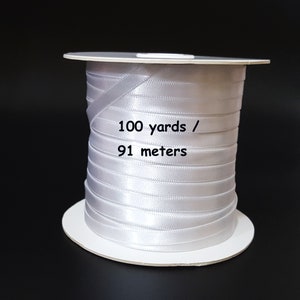 May include: A spool of white satin ribbon, 100 yards / 91 metres long.