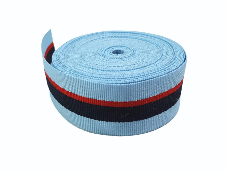 May include: A roll of light blue ribbon with a black and red stripe. The ribbon is approximately 1 inch wide.