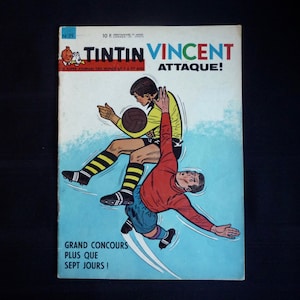 May include: A vintage comic book cover featuring Tintin and Vincent in a soccer match. The cover is blue and white with the title "Tintin Vincent Attaque!" in red and black lettering. The text "Grand Concours Plus Que Sept Jours!" is printed in black at the bottom of the cover.