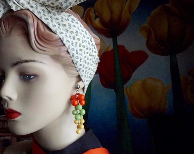 Dangling earrings. Clusters of orange, yellow and green plastic balls. 1960. Vintage earring. Fashionista.