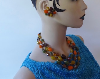 Ensemble collier 3 rangs et clips vintage. Plastique orange, vert, marron et jaune imitation pierre. Année 50. Fermoir à crochet.