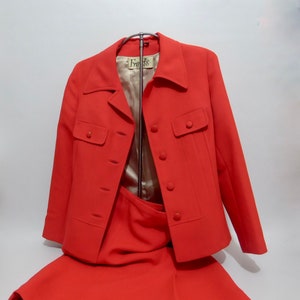 May include: A red skirt suit with a matching jacket and skirt. The jacket has a label that says "Fran's".
