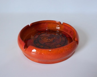Round ashtray in orange glazed clay. 1970. Sun graphic. Seventies decor. Mid-century pottery.