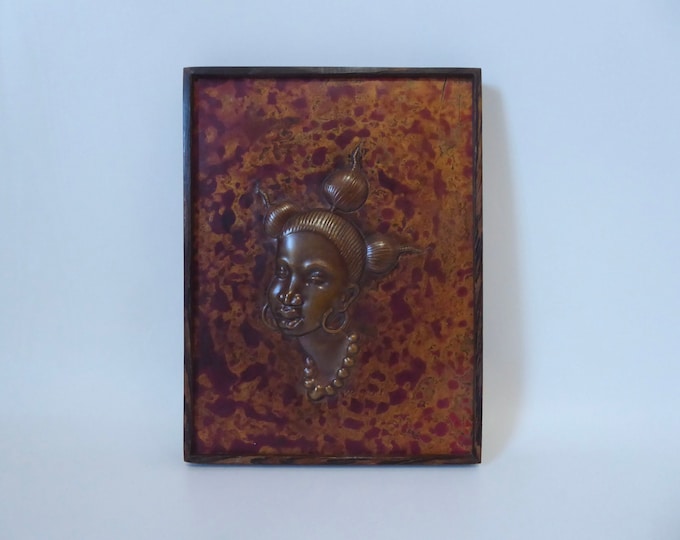 Kongolo. Copper bas-relief of a woman's face. Zaire. 1970. Ebony veneered wood frame. African art. Embossed copper.