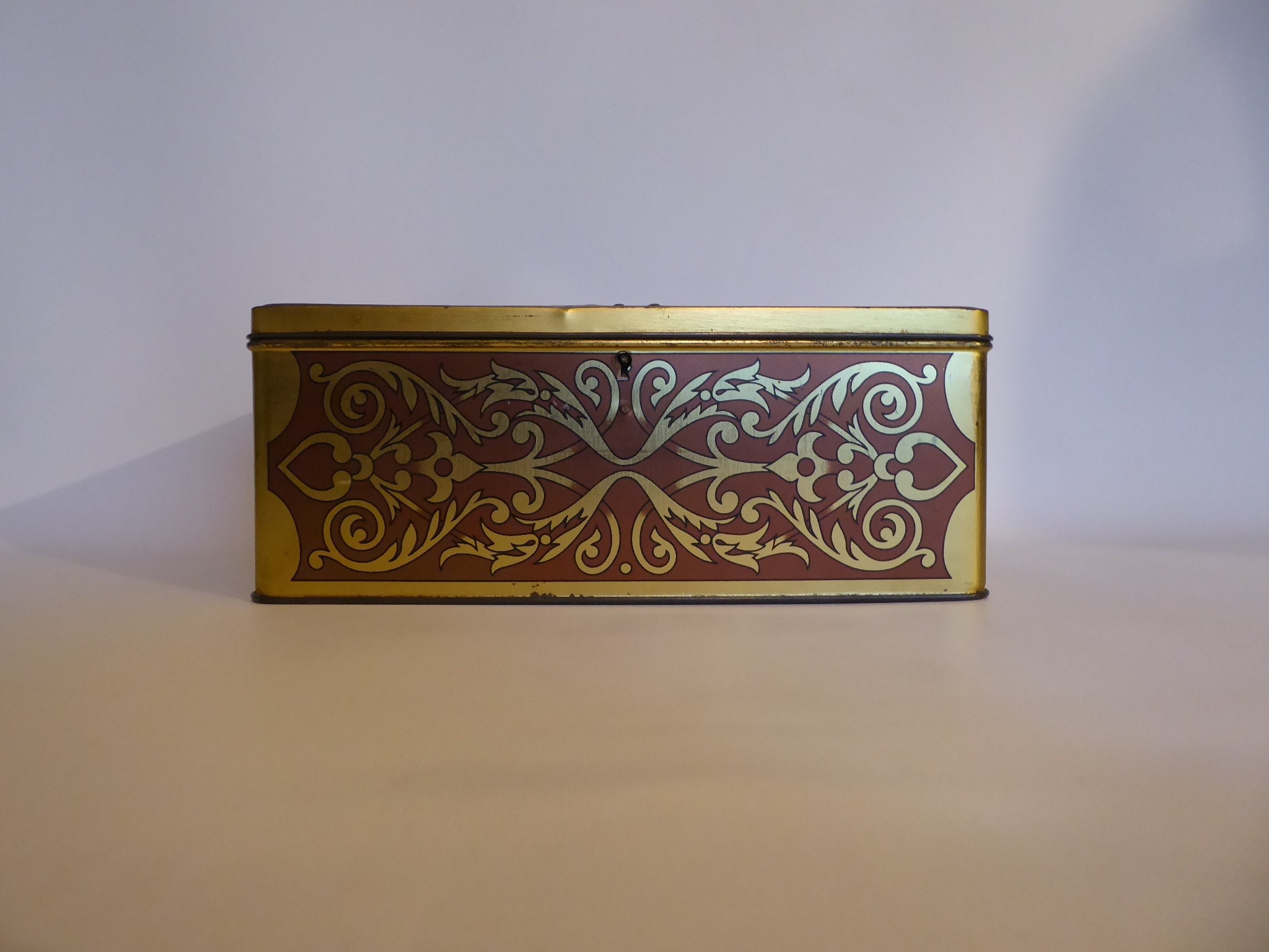 Large vintage metal box with lock. Scene farm inn 17th century. Golden geometric designs. Year