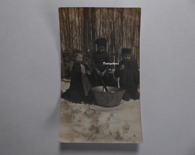 Sepia photograph of children in a maple grove. Tasting maple taffy. Around 1910. Quebec winter. Quebec heritage. Children in the snow.