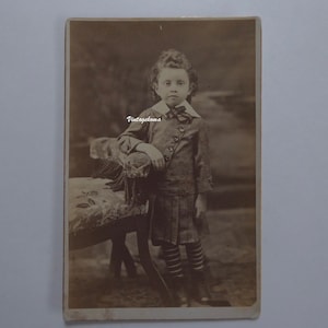 Photographie enfant 1880. Sépia. CDV. Tranches dorées. Petit garçon cheveux longs. Ruban tartan au cou. Veston boutonnière diagonale.