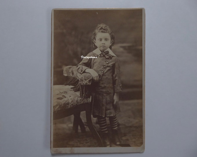 Child photograph 1880. Sepia. CDV. Gold edges. Little boy with long hair. Tartan ribbon around neck. Diagonal buttonhole jacket.