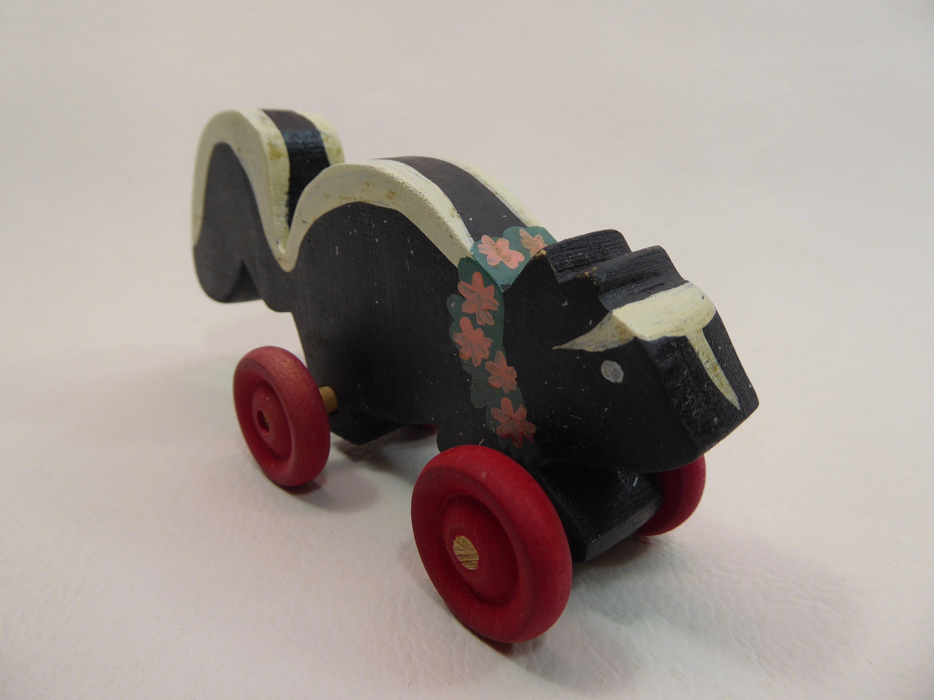 Skunk figurine. Skunk. Toy on wheels. Vintage wood carving. 1960's