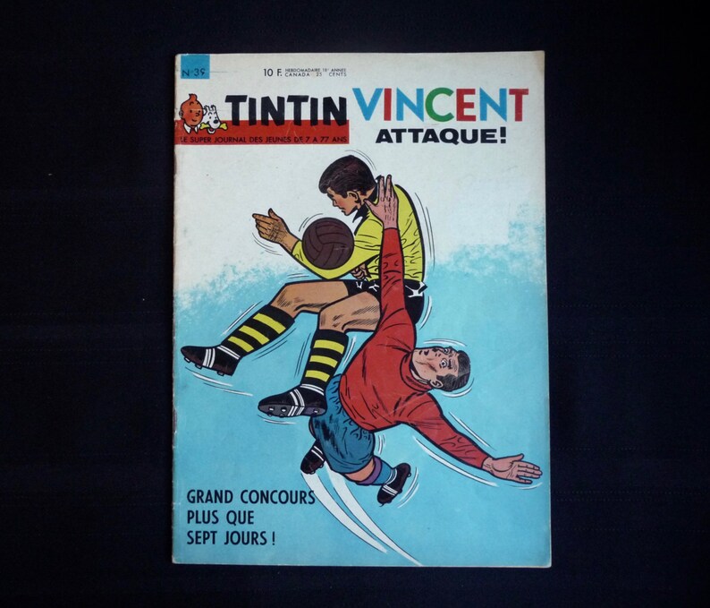 May include: A vintage comic book cover featuring Tintin and Vincent in a soccer match. The cover is blue and white with the title "Tintin Vincent Attaque!" in red and black lettering. The text "Grand Concours Plus Que Sept Jours!" is printed in black at the bottom of the cover.