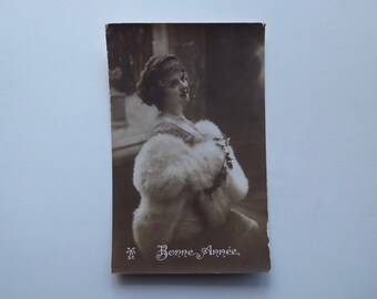 Carte postale Bonne année 1914. Jeune femme avec cape de fourrure blanche.  Temps des fêtes. Carte postale française