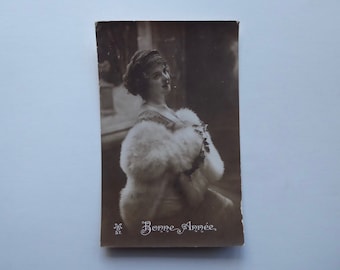 New Year's postcard, 1914. Young woman in a white fur cape. Holiday season. French postcard