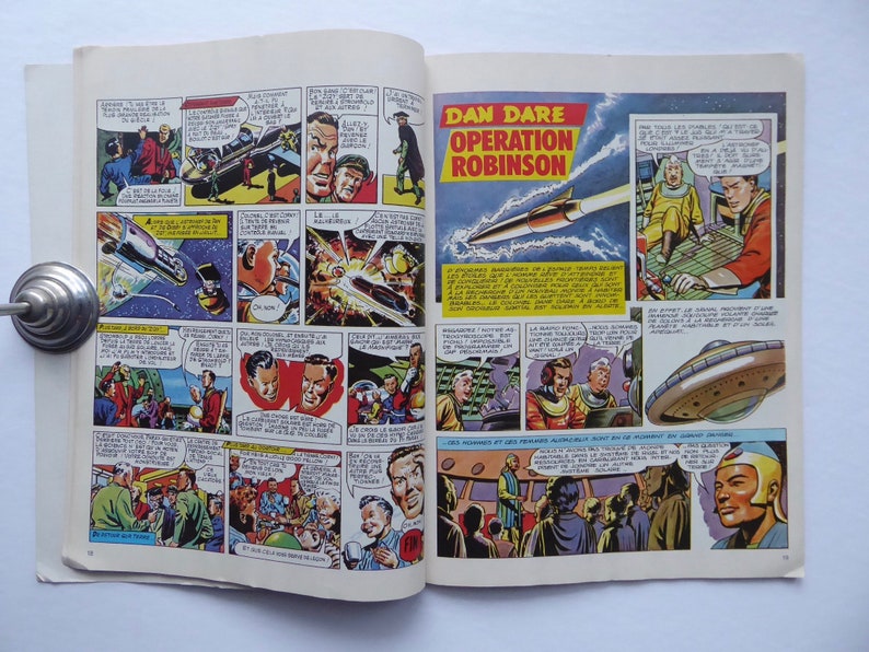 May include: A comic book page featuring Dan Dare, Operation Robinson. The page is filled with colourful illustrations of spaceships, characters, and a futuristic setting. The text reads "Dan Dare, Operation Robinson".