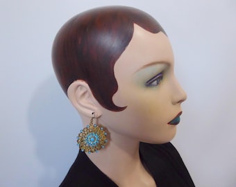 Gold filigree metal drop earrings with a shiny finish and turquoise blue bead. 1980.