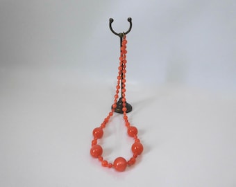 Iridescent salmon-colored plastic bead necklace. 1960