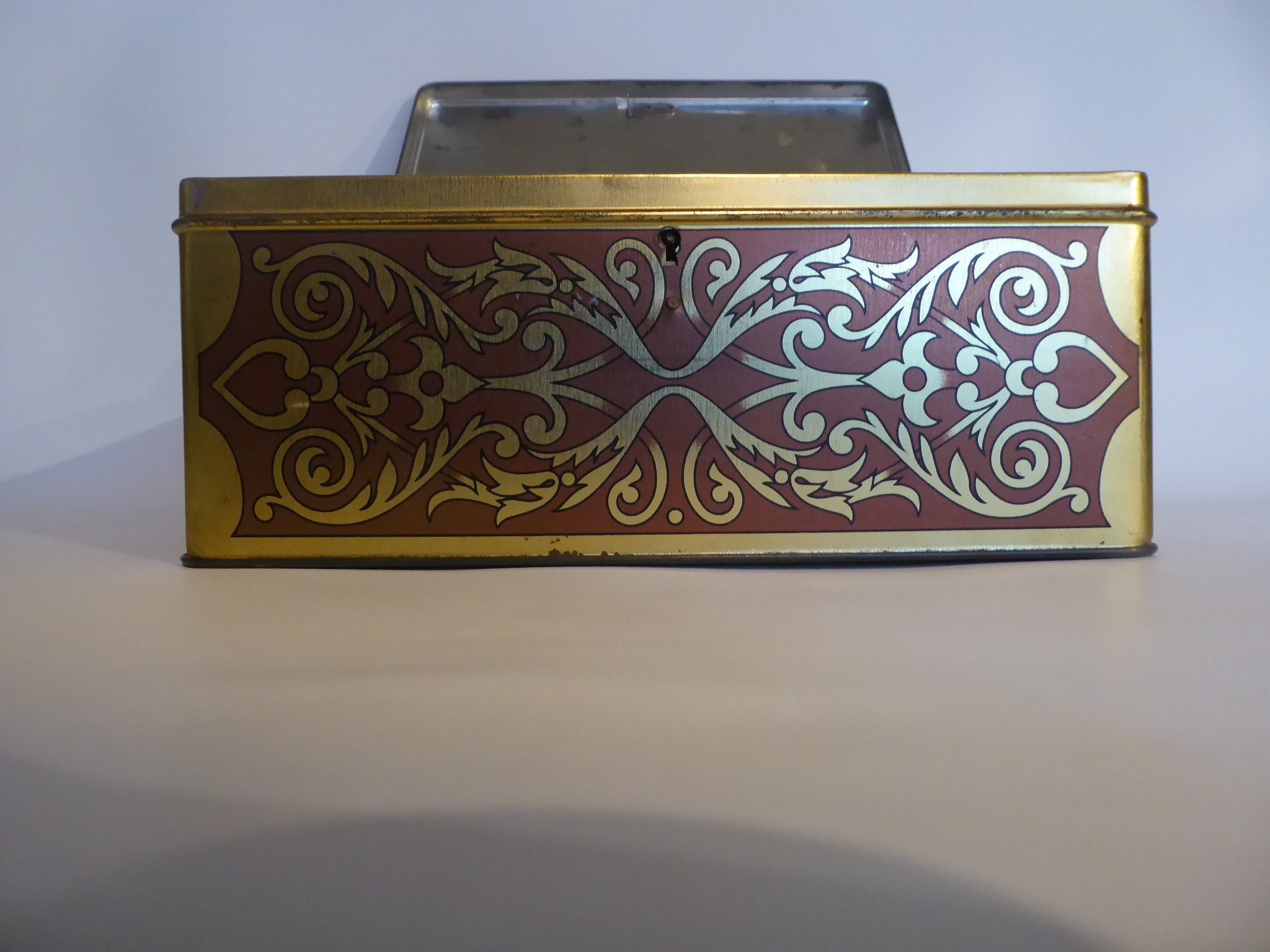 Large vintage metal box with lock. Scene farm inn 17th century. Golden geometric designs. Year