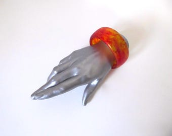 Translucent yellow resin bangle bracelet with red veining. 1980s. Vintage jewelry.