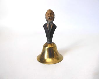 Small service bell with a carved wooden handle depicting a man's torso. Circa 1920.