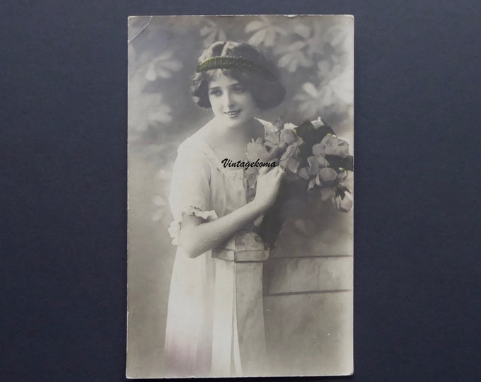 Postcard of a young woman 1900-10. Monochrome. Flower bouquet. Lace neckline dress. International Fine Arts Company, Montreal.