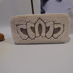 May include: A white beaded clutch bag with the word "SCOTTS" spelled out in brown beads.