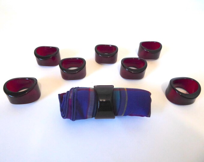 8 red wine-colored plastic napkin rings. Year 1990