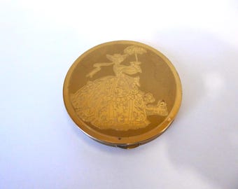 Wadsworth Compact. Made in the USA. Vintage brass compact. Engraved motif of a woman with a hat and parasol. 1950s.