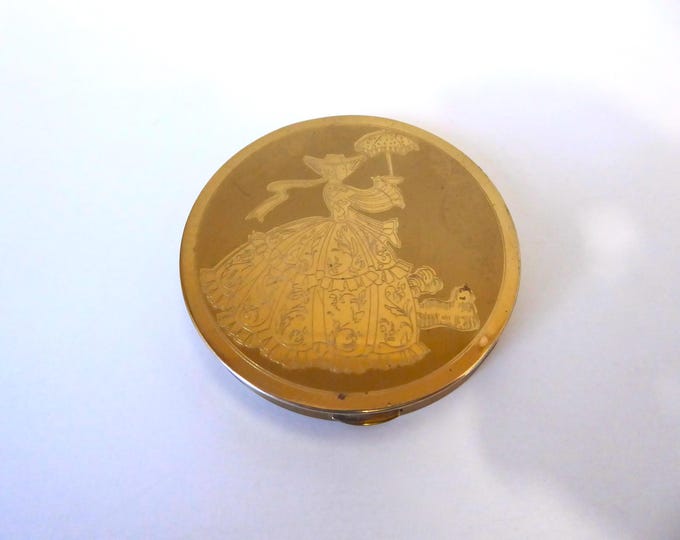 Wadsworth Compact. Made in USA. Vintage brass powder compact. Engraved motif of a woman with a hat and parasol. 1950s.