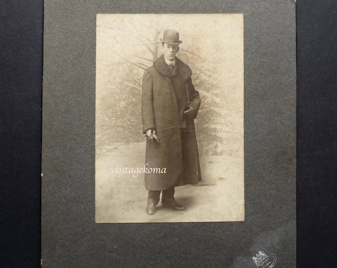 Sepia photography. 1900-1910. Topley Studio. Ottawa. Man standing. Bourgeois. Ball hat. Fur collar overcoat. Gloves. Winter décor.