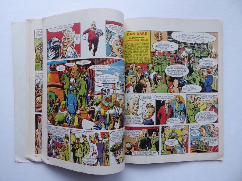 May include: A comic book open to a page featuring a colourful illustration of a group of people in military uniforms. The text on the page reads "Dan Dare, Pilot of the Future, Course in Space".