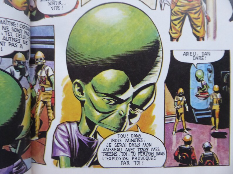 May include: A comic book page featuring a green alien character with large eyes and a pointed head. The alien is wearing a purple shirt and has a speech bubble that says "FOU! DANS TROIS MINUTES. JE SERAI DANS MON VAISSEAU AVEC TOUS MES TREENS. TOI. TU PERIRAS DANS L'EXPLOSION PROVOQUEE PAR TOI!"