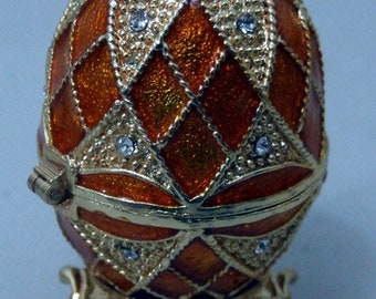Russian Replica Diamond Patterns w/small triangular pieces w/ three leg base Faberge egg, opens to an area for goodies.
