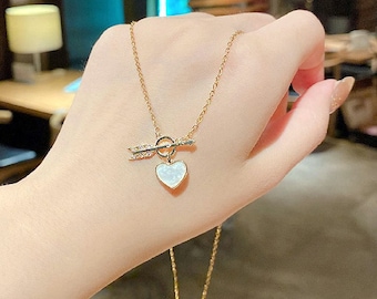 Una elegante flecha de acero inoxidable con colgante de corazón de concha con cadena de 40 cm