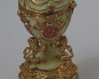 Russian Replica Gold, Off/White and Reddish A Structure with 3 Lions holding up an Egg with gold decor and more...