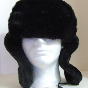 Puede incluir: Un gorro trapero de piel sint&eacute;tica negra con orejeras y una correa para la barbilla.