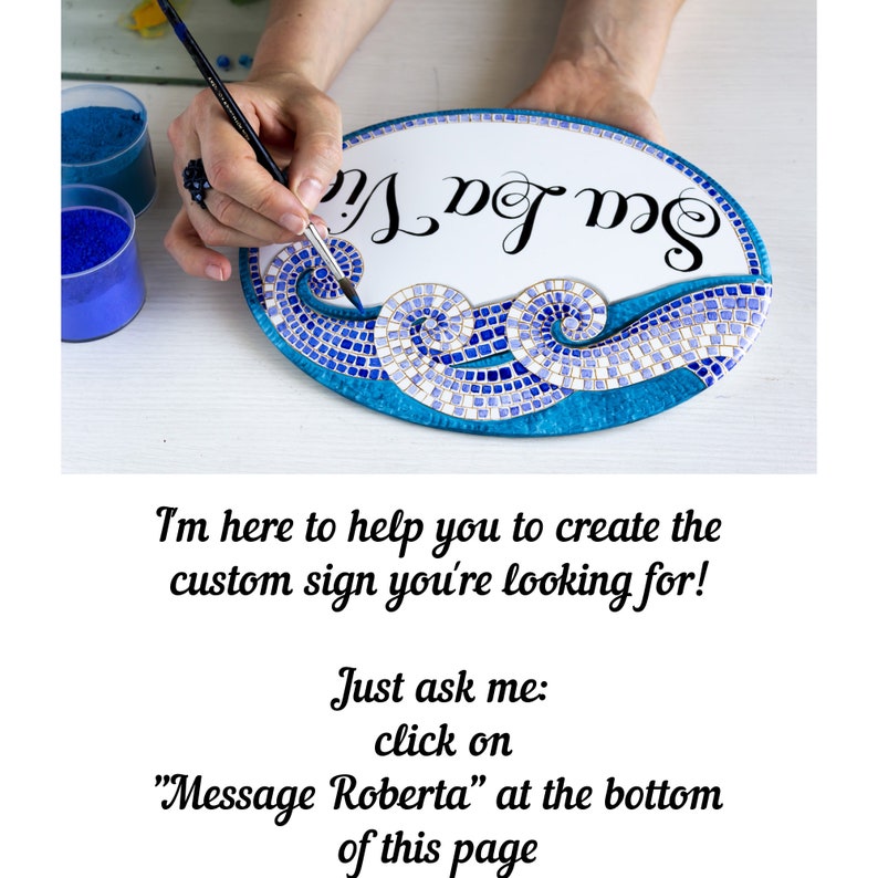May include: A hand paints a custom sign with the words "Mug Me" in black cursive lettering. The sign is oval shaped and has a blue and white mosaic design with a wave pattern.