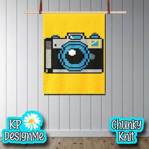 May include: A yellow chunky knit wall hanging with a pixelated camera design in black, white, and blue. The wall hanging is suspended from a wooden dowel with leather straps. The text "KP DesignMe" and "Chunky Knit" are also visible.
