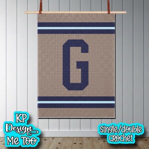 May include: A rectangular wall hanging featuring a textured tan background with a large navy blue letter G in the center. The design includes horizontal navy blue and light blue stripes at the top and bottom. The text KP Design Me Too and single/double crochet are visible.