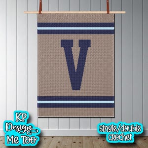 May include: A rectangular crochet wall hanging featuring a large dark blue letter V centered on a tan background. The design includes horizontal stripes of dark blue and light blue at the top and bottom. The text KP Design Me Too and single/double crochet are visible.