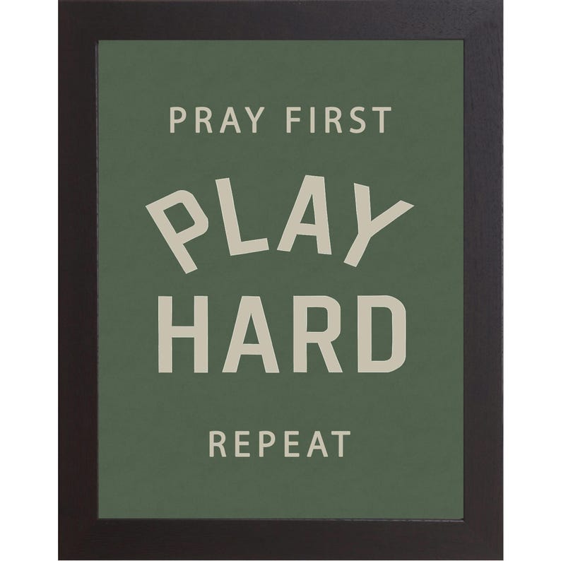 Black color frame of a Christian sports framed wall art with the phrase Pray First Play Hard Repeat on a green background in a vertical layout