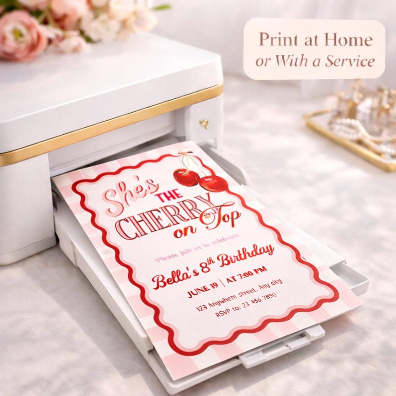May include: A white printer with gold trim is printing a birthday invitation. The invitation features a red and pink cherry design with the text "She's the Cherry on Top" and details for Bella's 8th birthday.