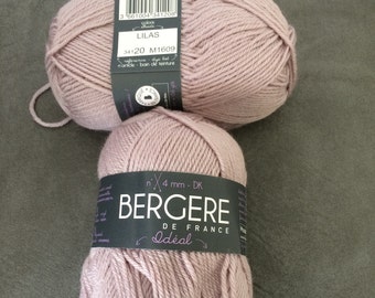 May include: Two skeins of light lilac yarn stacked vertically. Each skein features a black paper label with white text reading Bergere de France, Idéal, and 4 mm. The top label includes a barcode and the color name Lilas, while the bottom label displays the brand name prominently.